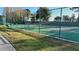 Outdoor community tennis court surrounded by mature landscaping and a fence at 2932 Bayhead Run, Oviedo, FL 32765