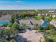 Runaway Bay Condo aerial view featuring a lake, lush landscaping, and vibrant buildings at 3002 Bonfire Beach Dr # 202, Kissimmee, FL 34746