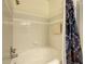 Bathroom with a shower-tub combo and white tile surround and a decorative shower curtain at 3002 Bonfire Beach Dr # 202, Kissimmee, FL 34746