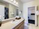 Bathroom with a large vanity, mirror, and walk-in closet with wire shelving at 3002 Bonfire Beach Dr # 202, Kissimmee, FL 34746