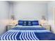 Comfortable bedroom featuring a striped blue comforter, nautical themed pillows, and bedside tables with lamps at 3002 Bonfire Beach Dr # 202, Kissimmee, FL 34746