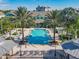 Stunning community pool area featuring lush landscaping, palm trees, and plenty of lounge seating at 3002 Bonfire Beach Dr # 202, Kissimmee, FL 34746