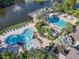 Overhead shot of community pools near lake; features splash zone, swimming, & lounging areas at 3002 Bonfire Beach Dr # 202, Kissimmee, FL 34746