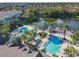 Stunning aerial showcases community pools, lake with fountain, lounge areas surrounded by palm trees at 3002 Bonfire Beach Dr # 202, Kissimmee, FL 34746