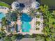 Aerial view of a rectangular pool with sundeck, umbrellas, lounge chairs and tropical landscaping at 3002 Bonfire Beach Dr # 202, Kissimmee, FL 34746