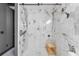 Modern bathroom featuring marble walls, a glass shower door, and a built-in wooden bench for added convenience at 3007 E Central Blvd # 3007, Orlando, FL 32803