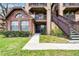 Charming condo entrance featuring well-manicured landscaping, brick accents, and a private entrance with wooden stairs at 305 Lakepointe Dr # 103, Altamonte Springs, FL 32701