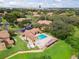 Aerial view of a community pool, lounge chairs, and clubhouse surrounded by lush landscaping and condo buildings at 305 Lakepointe Dr # 103, Altamonte Springs, FL 32701