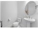 Stylish half bathroom features a modern pedestal sink and round mirror at 3186 Sailing Pier Ave, Winter Garden, FL 34787