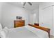 Bright bedroom with a ceiling fan, white linens and matching wooden furnishings at 3186 Sailing Pier Ave, Winter Garden, FL 34787