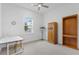 Neutral bedroom featuring a window, ceiling fan, desk and storage cabinets at 3186 Sailing Pier Ave, Winter Garden, FL 34787