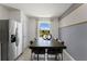 Dining area featuring a dark wood table, seating for six, stainless steel refrigerator, gray accent wall, and a window view at 3322 Wye Oak Dr, Apopka, FL 32703