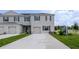 Two story townhome featuring gray exterior paint, a driveway, small bushes, and green grass at 3322 Wye Oak Dr, Apopka, FL 32703
