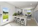 Open kitchen featuring white cabinets, an island with barstool seating, stainless steel appliances, and sightlines to the dining room at 3322 Wye Oak Dr, Apopka, FL 32703