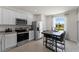 Modern kitchen with white cabinets, stainless steel appliances, gray countertops and tile floors, and an eat-in kitchen table at 3322 Wye Oak Dr, Apopka, FL 32703