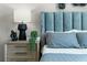 Close up of the main bedroom with a blue upholstered headboard and a matching blue bedside lamp at 3322 Wye Oak Dr, Apopka, FL 32703