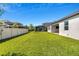 Backyard view showing a lush lawn, white fence, and neighboring houses at 3351 Pine Timber Pt, Oviedo, FL 32765
