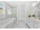 Bright bathroom featuring a soaking tub, separate shower, dual sink vanity, and white marble throughout at 3351 Pine Timber Pt, Oviedo, FL 32765