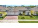 Charming one-story home featuring a three-car garage, brick driveway, lush green lawn and manicured landscaping at 3351 Pine Timber Pt, Oviedo, FL 32765