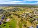 This aerial view shows the home's location on a lush golf course with mature trees and well maintained landscaping at 34000 Fortunado St, Sorrento, FL 32776
