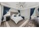 Comfortable bedroom with tufted headboard, blue accents, large fan, and decorative blue curtains at 34000 Fortunado St, Sorrento, FL 32776