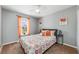 Cozy bedroom with colorful bedding, bright orange curtains, and a large window at 34000 Fortunado St, Sorrento, FL 32776