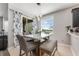 Cozy dining area bathed in natural light, featuring a stylish table, chairs, and large windows at 34000 Fortunado St, Sorrento, FL 32776