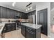 Modern kitchen boasts stainless steel appliances, black cabinets, and a central island with marble countertop at 34000 Fortunado St, Sorrento, FL 32776
