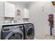 Laundry room featuring side-by-side washer and dryer with overhead cabinets at 34000 Fortunado St, Sorrento, FL 32776