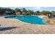 Community pool area includes a waterfall feature, multiple lounge chairs, and mature landscaping at 34000 Fortunado St, Sorrento, FL 32776