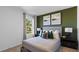 Well-lit bedroom showcasing a queen bed, stylish decor, and a pleasant view through the window at 3615 Salvia Ct, Tavares, FL 32778