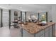 A modern kitchen with an island featuring a sink and granite countertops blends into the dining and living area at 3615 Salvia Ct, Tavares, FL 32778