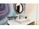 Modern bathroom featuring stylish wallpaper, a vessel sink, framed mirror, and contemporary fixtures at 3714 Virginia Dr, Orlando, FL 32803