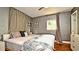 Cozy bedroom featuring a ceiling fan, floral bedding and curtains plus ample natural light from the window at 3714 Virginia Dr, Orlando, FL 32803