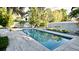 Backyard pool surrounded by well manicured landscaping and paver deck at 3714 Virginia Dr, Orlando, FL 32803