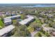 Community aerial showcasing mature trees, complex buildings, a community pool and nearby waterway at 3800 Saxon Dr # 19B, New Smyrna Beach, FL 32169