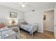Charming bedroom with twin beds, bright natural light, and adjacent bathroom at 3800 Saxon Dr # 19B, New Smyrna Beach, FL 32169