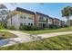 A welcoming condo complex with lush landscaping and well-maintained sidewalks on a bright, sunny day at 3800 Saxon Dr # 19B, New Smyrna Beach, FL 32169