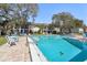 Sparkling community pool with chairs and umbrellas surrounded by lush landscaping at 3800 Saxon Dr # 19B, New Smyrna Beach, FL 32169