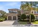 Charming Mediterranean style two-story home featuring a tile roof, manicured landscaping, and a two car garage at 415 Muirfield Loop, Reunion, FL 34747