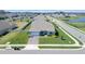 Aerial view of a single-Gathering home with a well-manicured lawn and a lake view in the distance at 4210 Sunset Preserve Blvd, Orlando, FL 32820