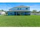 Backyard featuring a large lawn and a covered patio with outdoor furniture, perfect for relaxation at 4210 Sunset Preserve Blvd, Orlando, FL 32820