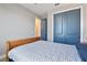 Comfortable bedroom showcasing a wooden bed frame and large closet with bright blue doors at 4210 Sunset Preserve Blvd, Orlando, FL 32820