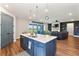 Kitchen island with sink, seating, and view to the living room and backyard patio at 4210 Sunset Preserve Blvd, Orlando, FL 32820