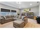 Bright living room with large sectional, bookshelves, and scenic views from the windows at 4210 Sunset Preserve Blvd, Orlando, FL 32820