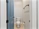 Efficient powder room with modern toilet, towel bar, and charming blue door at 4210 Sunset Preserve Blvd, Orlando, FL 32820