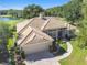 Aerial view of a well-maintained home showcasing lush landscaping, golf course, and lake views at 442 Devon Pl, Lake Mary, FL 32746