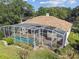 Aerial view of a home featuring a screened-in pool and well-manicured lawn at 442 Devon Pl, Lake Mary, FL 32746