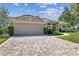 Charming single-story home featuring a brick driveway, well-maintained landscaping, and an attached two-car garage at 442 Devon Pl, Lake Mary, FL 32746