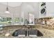 The kitchen showcases a stainless steel sink with granite countertops and a mosaic tile backsplash at 442 Devon Pl, Lake Mary, FL 32746